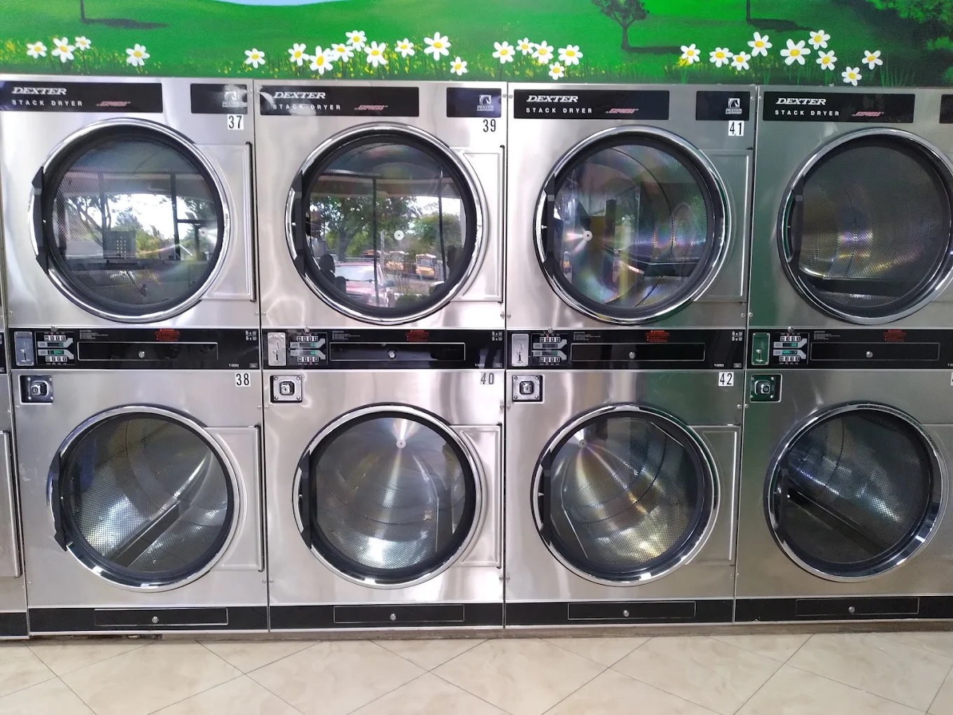 Washers, folding tables, and seating inside Polo Grounds Coin Laundry